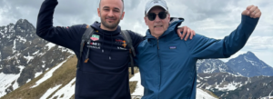 two men in hiking gear on mountaintop